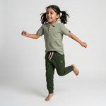 Kid wearing Kiggle Classic Polo in Dry Sage with forest joggers