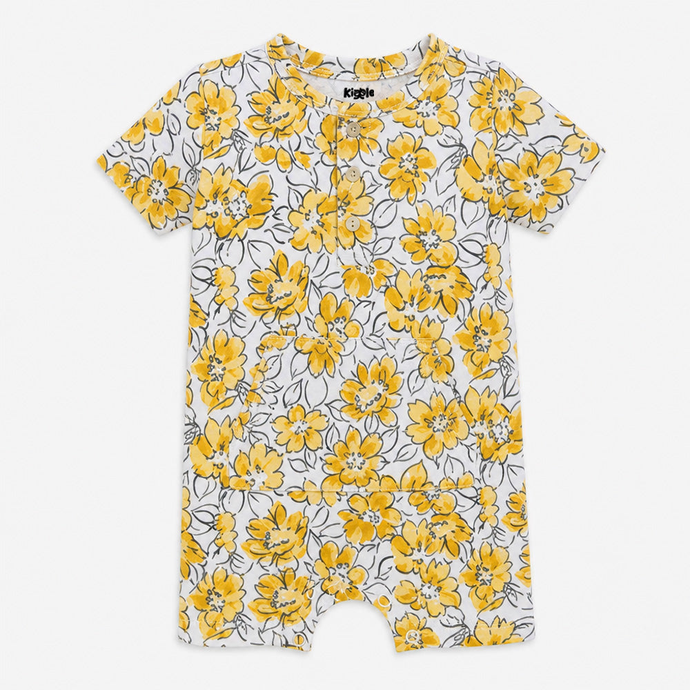 Kiggle organic cotton baby shorty romper in white with bold yellow sunflower print, tag-free and skin-safe, sizes 3 to 24 months